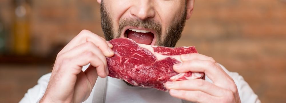 Man eats a steak as part of a high protein diet that could impact his fertility and erectile function