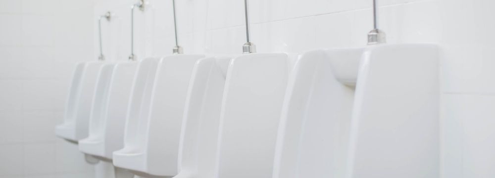 Row of urinals represents frustrating symptoms of BPH like urinary hesitancy and inability to fully empty the bladder 
