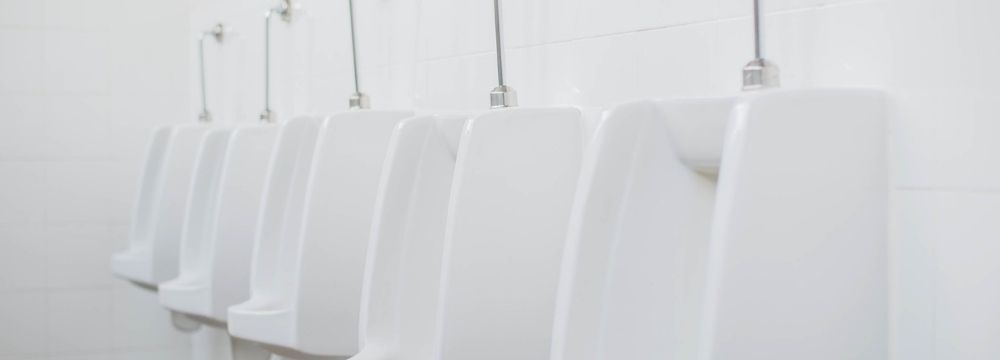 Row of urinals represents frustrating symptoms of BPH like urinary hesitancy and inability to fully empty the bladder