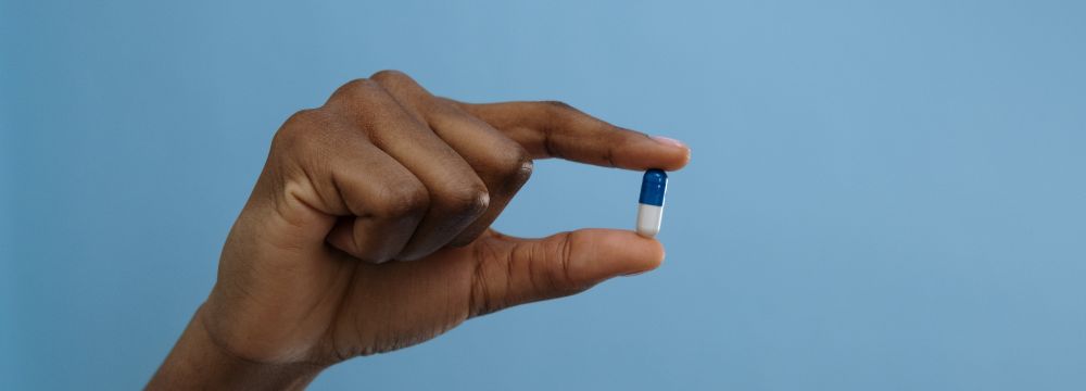 Man holds a supplement hoping it will help with his BPH symptoms 