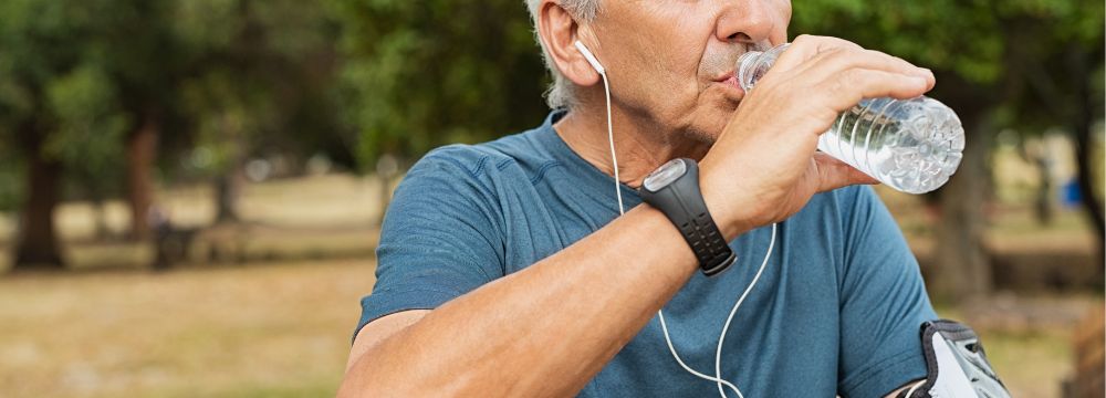 Man drinking from plastic water bottle while working out