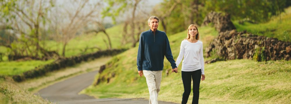 Man and wife walking down path holding hands