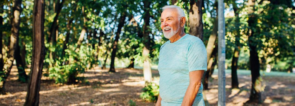 Older man walking along nature path