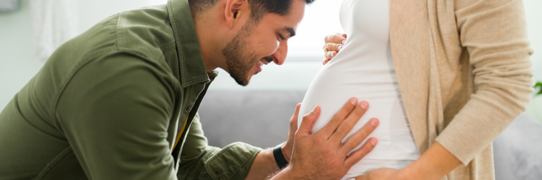Man placing hands on pregnant partner’s pregnant stomach