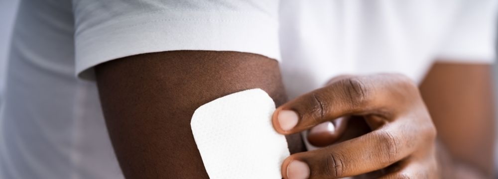 Man touching hormone patch on arm