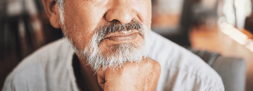 Man pondering, looking out window after prostate removal