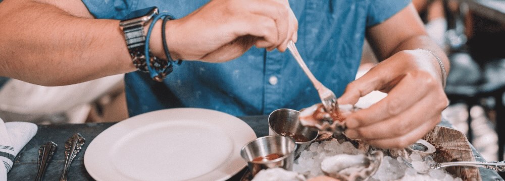 Man at restaurant eating oyster