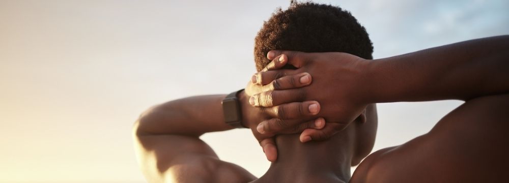 Man looking out with hands behind head, stretching